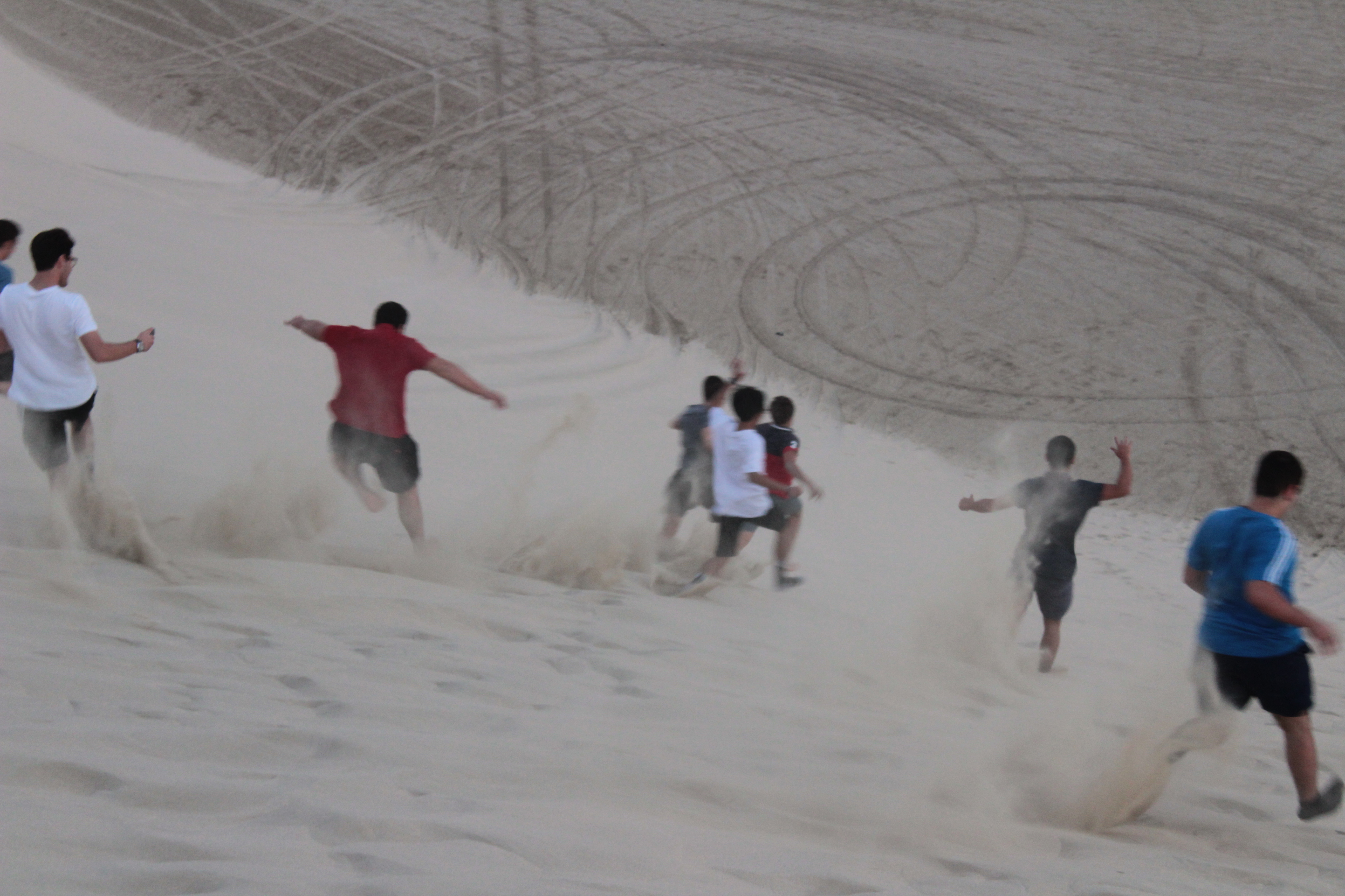 students running down sand dune